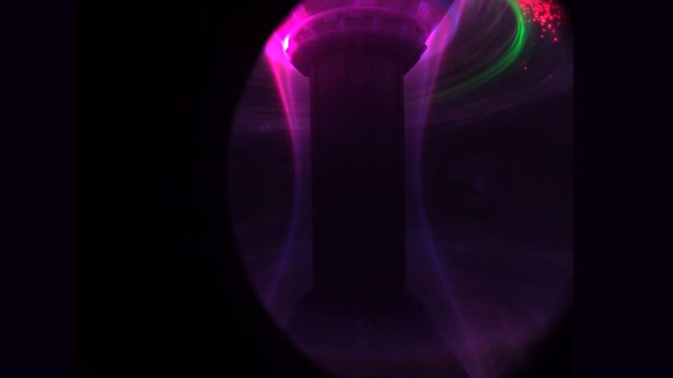 The plasma glows with a distinctive pink hue