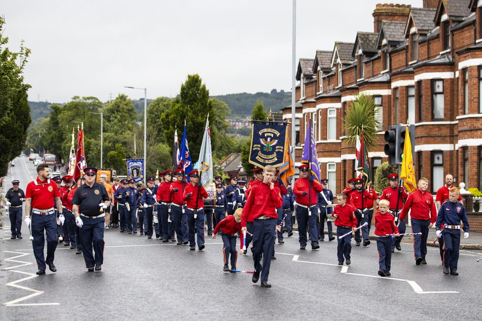 The Pride of Ardoyne flute band parading passed Ardoyne shops in north Belfast