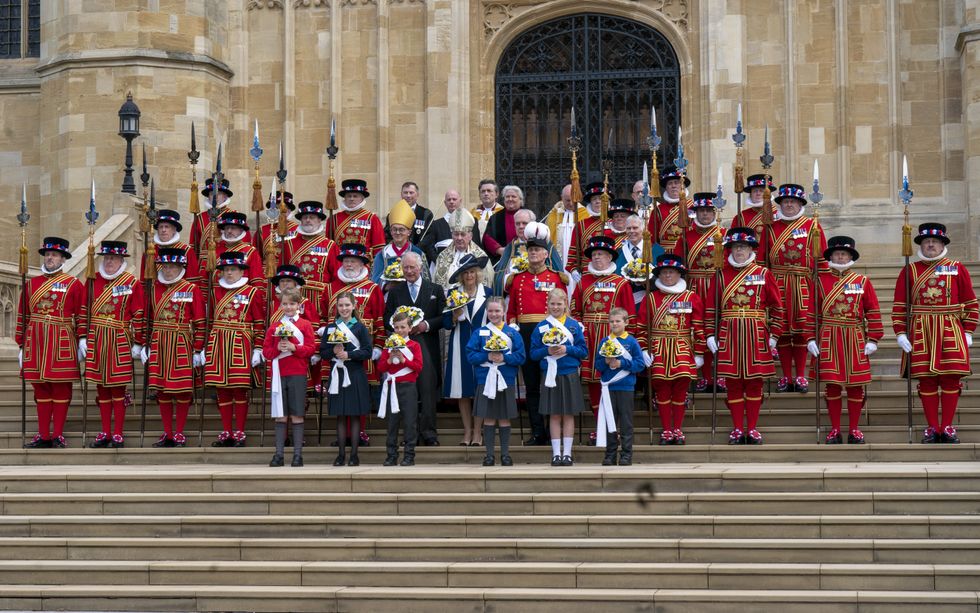 The Prince of Wales and Duchess of Cornwall (both centre front), representing the Queen, pose for a group photograph with members of the Queen's Body Guard of the Yeomen of the Guard, following the Royal Maundy Service at St George's Chapel, Windsor. Picture date: Thursday April 14, 2022.