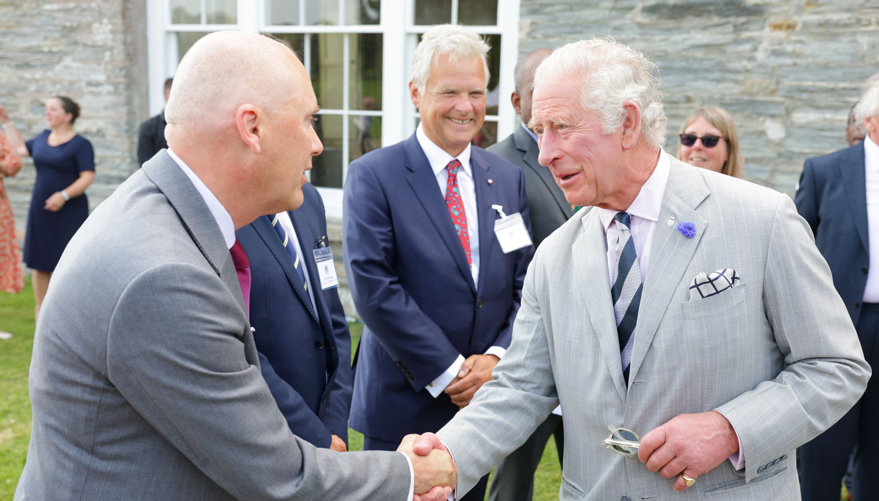 The Prince of Wales shakes hands with a guest at a garden party at Boconnoc House, Lostwithiel, Cornwall to mark the 70th anniversary of The Prince of Wales being head of the Duchy of Cornwall on the first day of their annual visit to the South West. Picture date: Monday July 18, 2022.