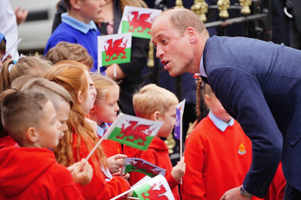 The Prince of Wales speaks to school children as he arrives for a visit to St Thomas Church, in Swansea, Wales