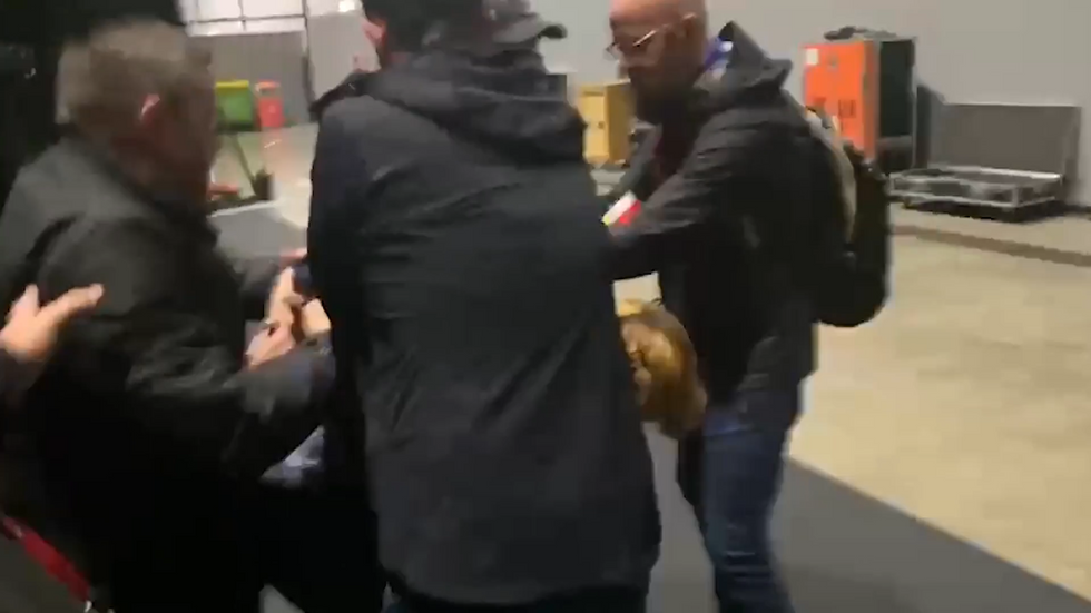 The protester is ejected from the conference hall