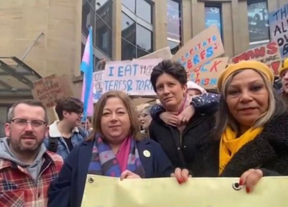 The SNP politicians were stood in front of a sign calling for women's rights campaigners to be decapitated
