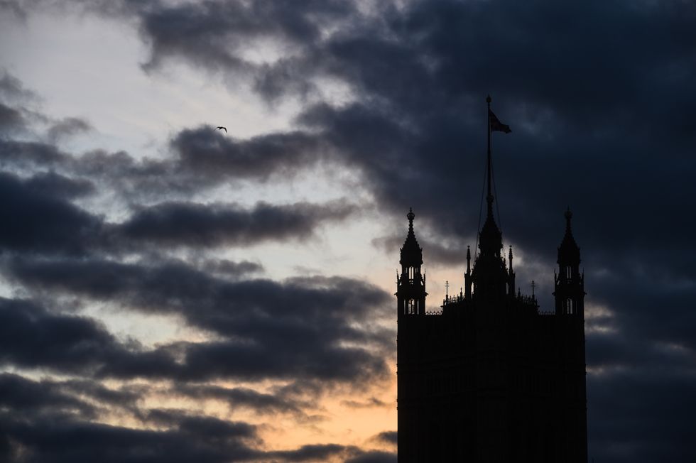 The sun sets behind the Houses of Parliament in Westminster.