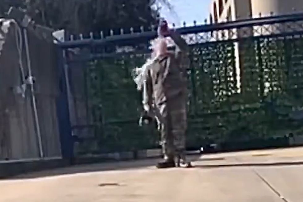 The US airman can be seen dousing himself in a fluid