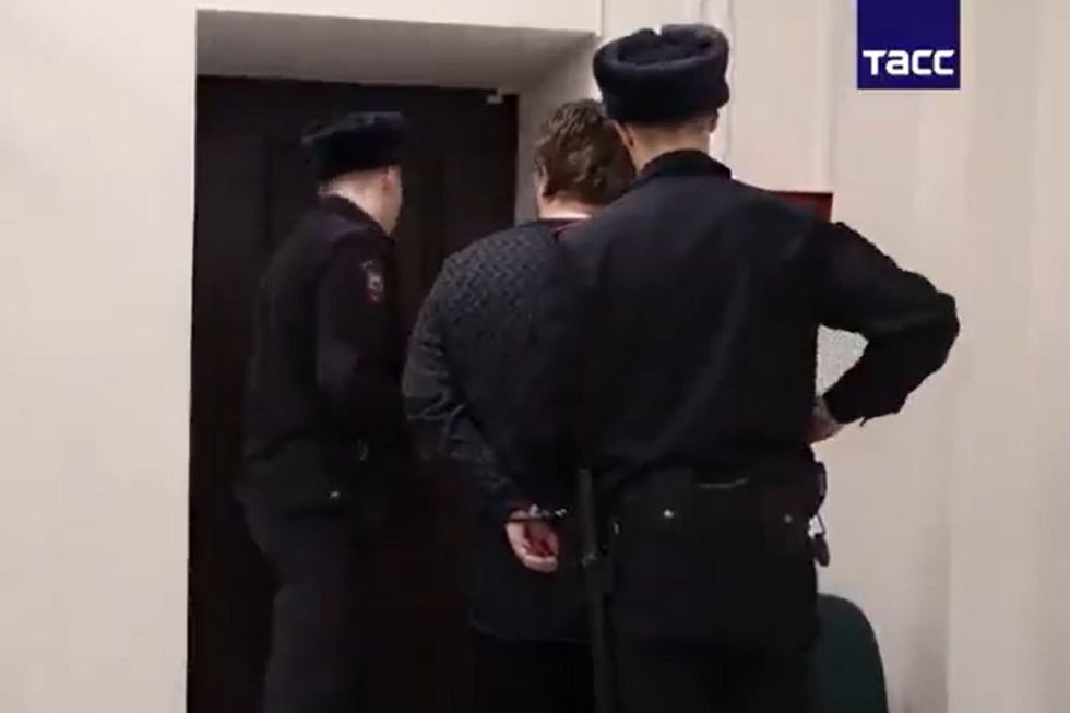 The video depicts him having his mobile phone confiscated before being handcuffed and interrogated inside a black vehicle