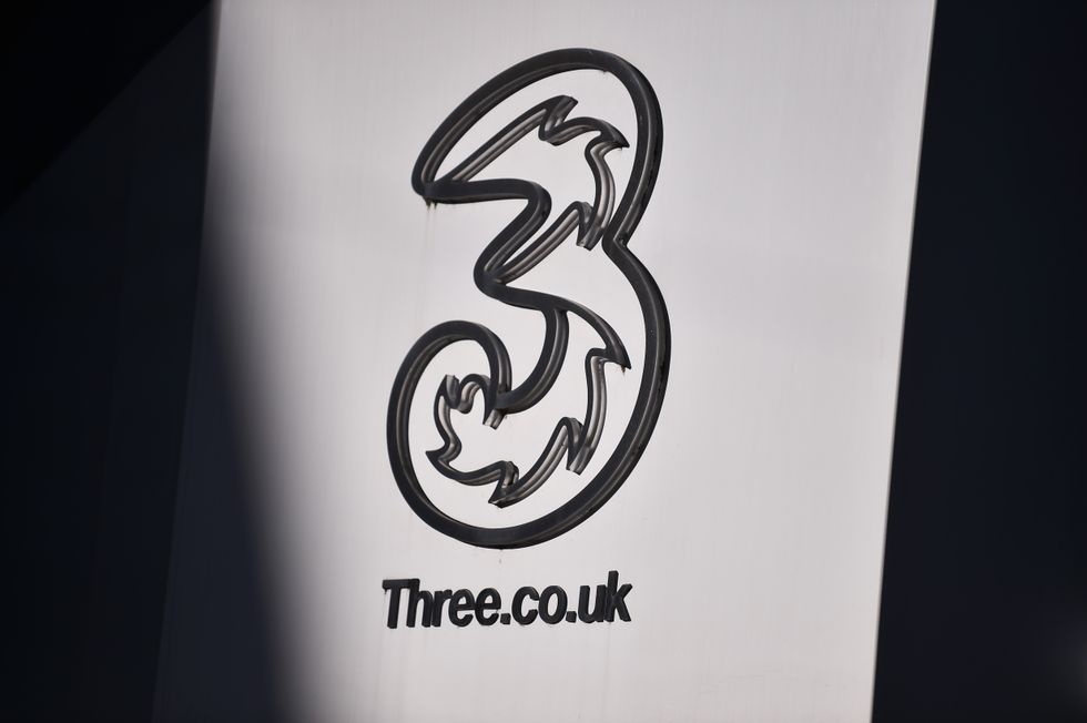 three UK mobile logo on a sign outside of a shop