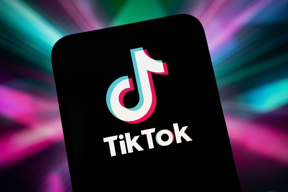 TikTok app logo on mobile in front of colourful background