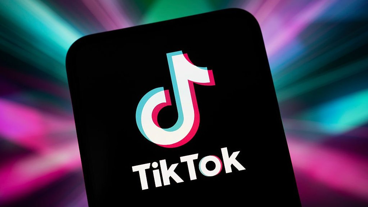 TikTok app logo on mobile in front of colourful background