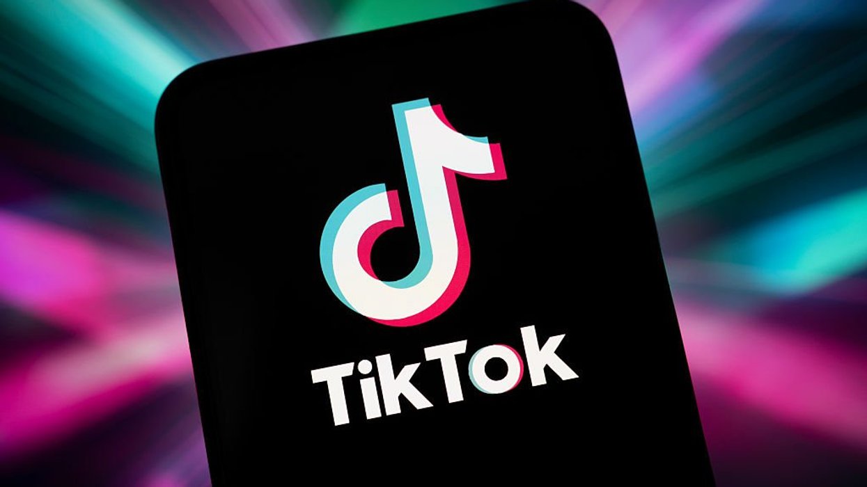 TikTok app logo on mobile in front of colourful background