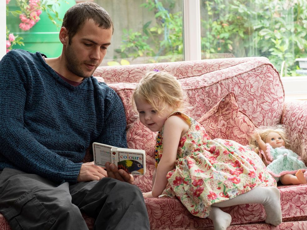Toddler and uncle learning about colours from a book
