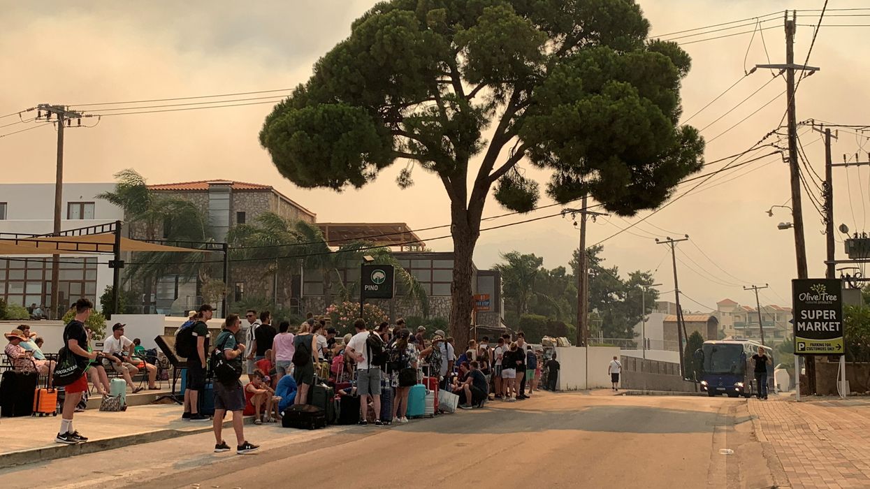 Tourists are evacuated as wildfires rage on
