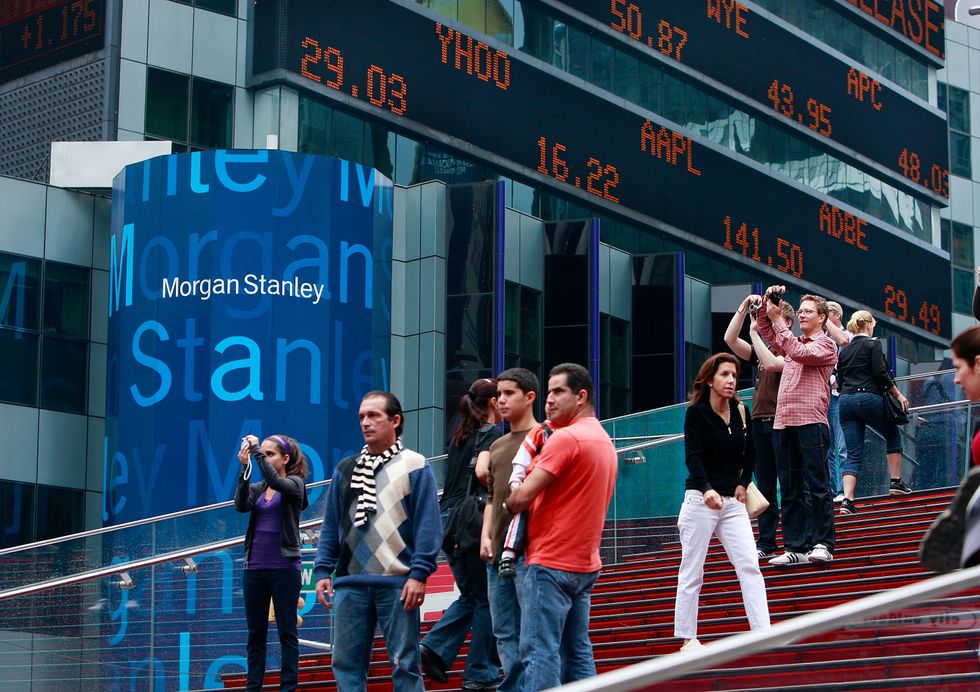 Tourists take photos in front of Morgan Stanley headquarters