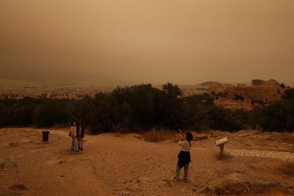 Tourists visit the Filipappou hill with the views of the Acropolis