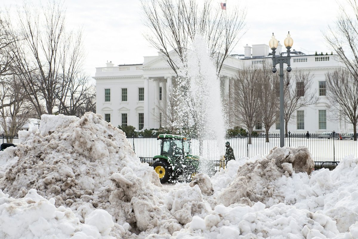 Tractors clear mountains of snow outside the White House in January 2016