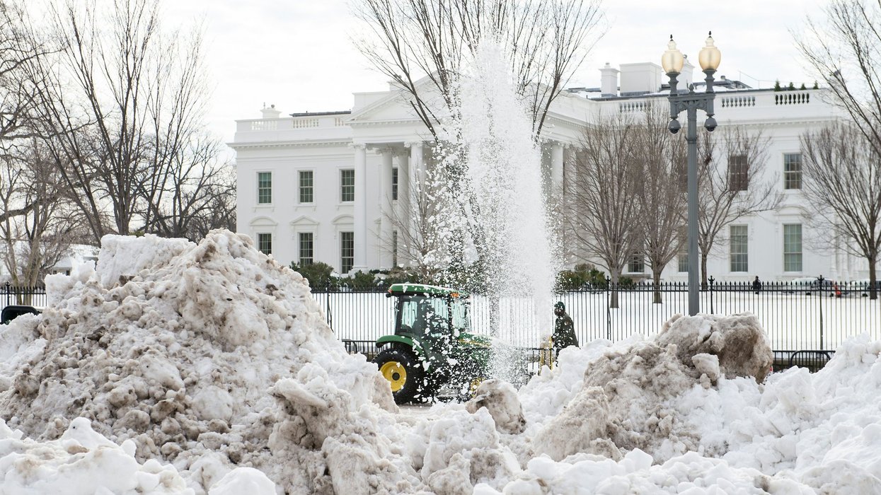 Tractors clear mountains of snow outside the White House in January 2016