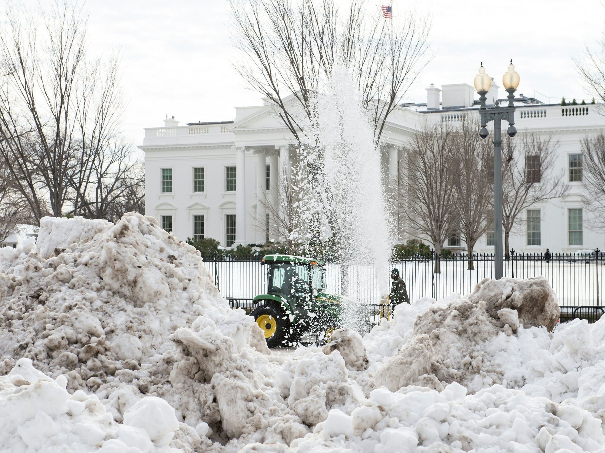 Tractors clear mountains of snow outside the White House in January 2016