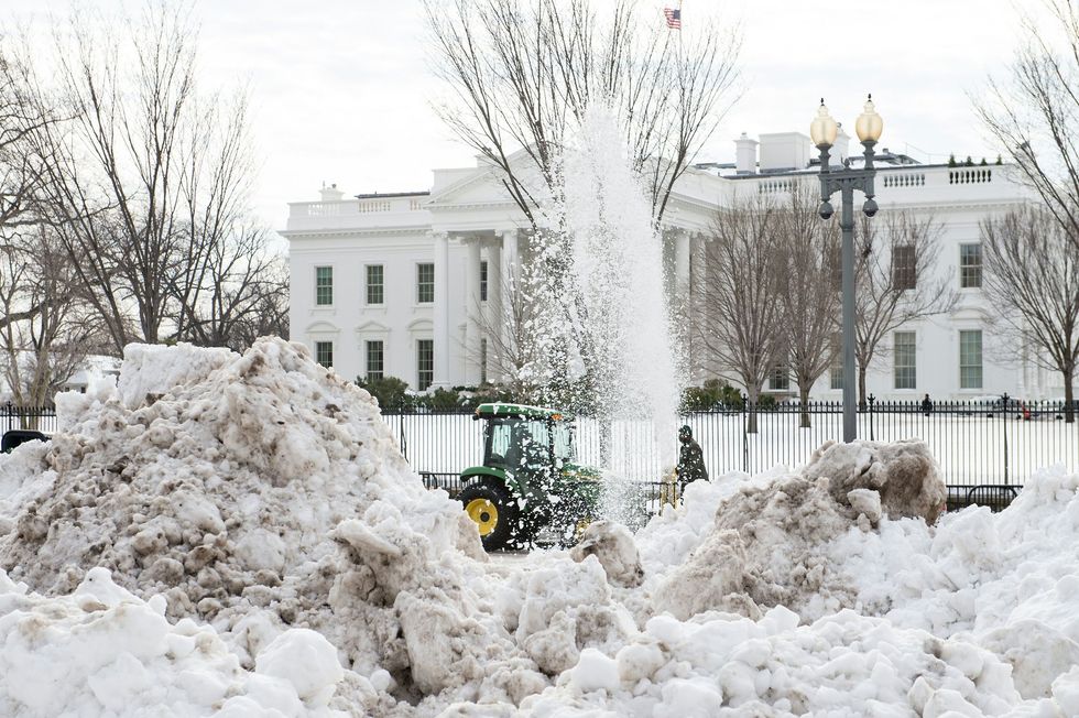 Tractors clear mountains of snow outside the White House in January 2016