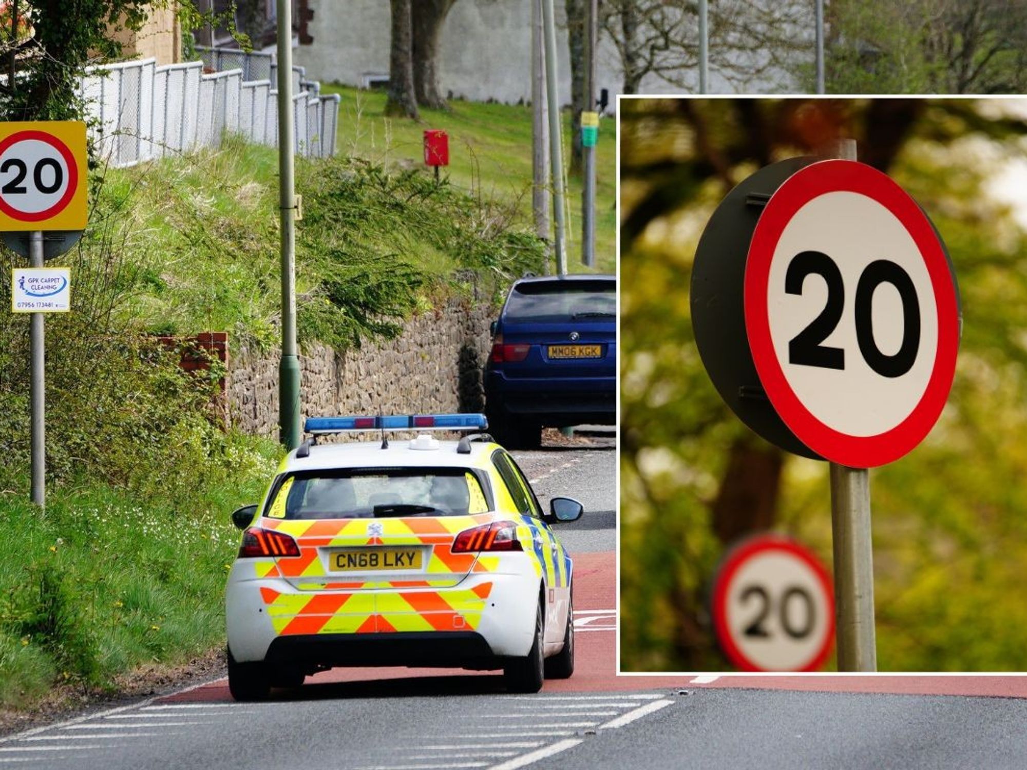 Traffic driving past a 20mph speed limit sign and a 20mph sign