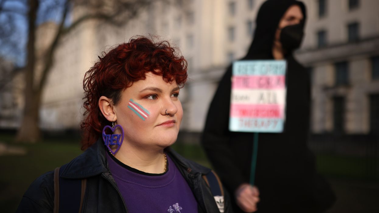 Trans rights activist wears an earring featuring a 'they' pronoun symbol, during a protest outside the Ministry of Defence Main Building