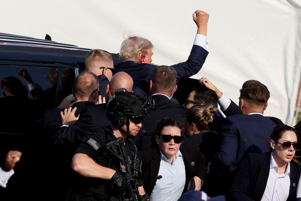 Trump with a bloodied ear was escorted into a car