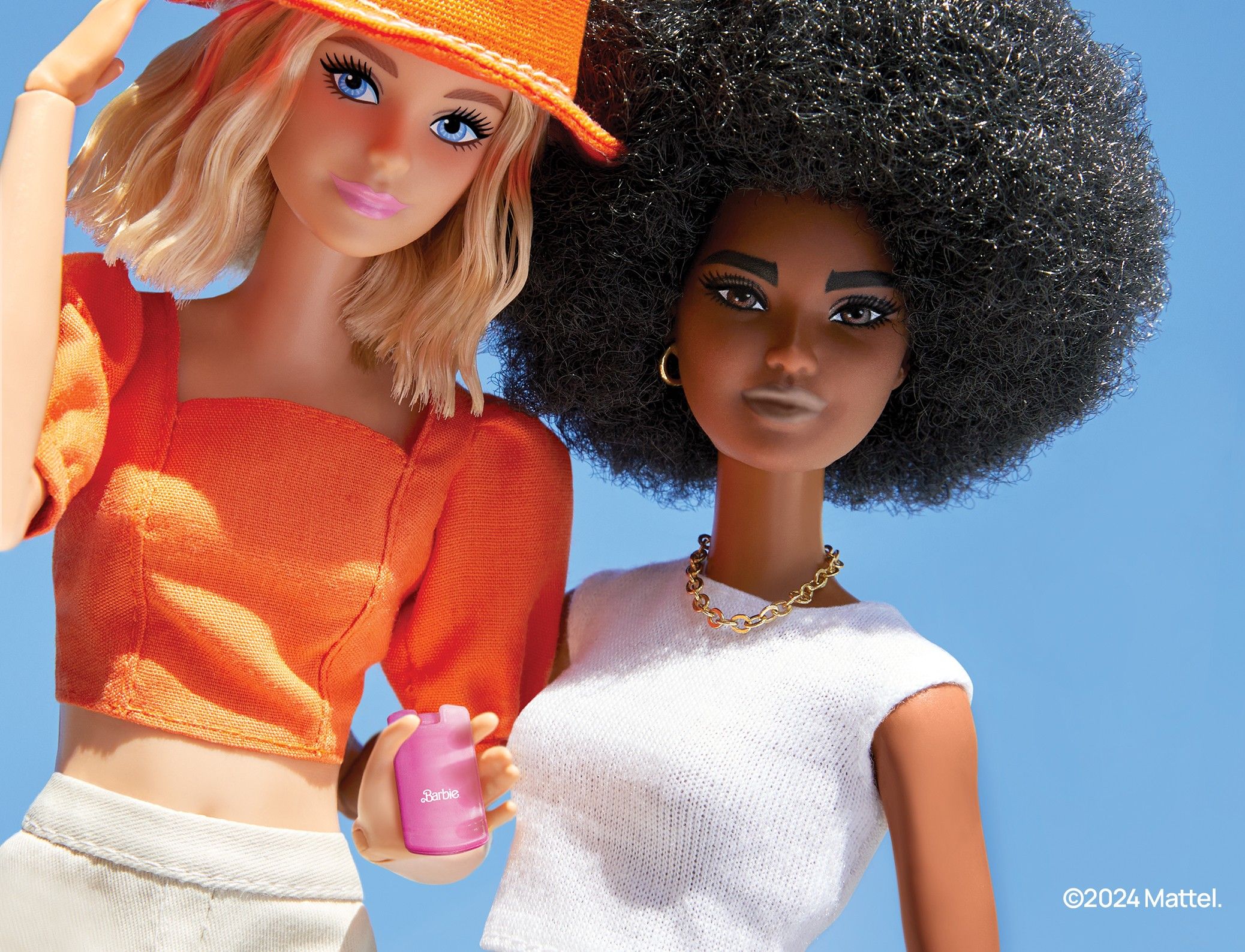 two barbie dolls pictured side by side while one holds the trademark pink flip phone