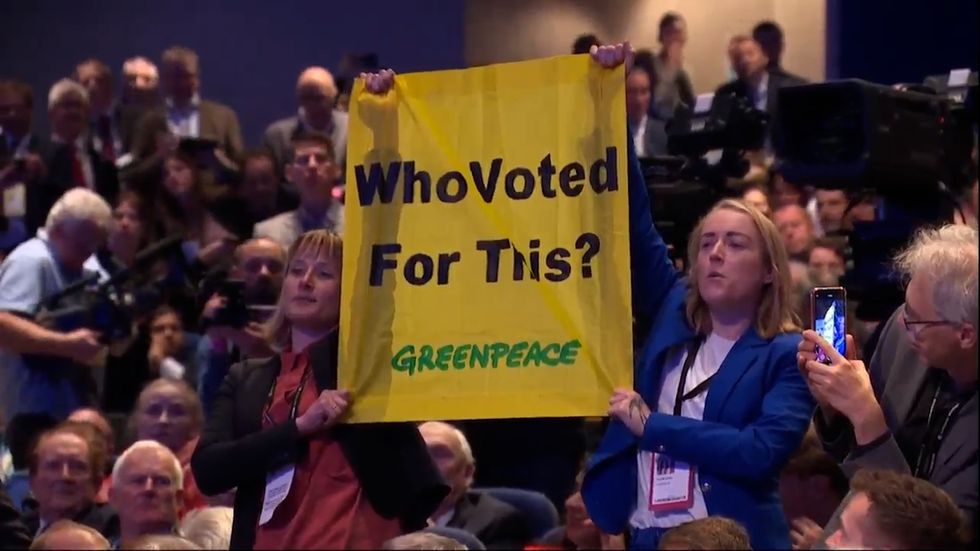 Two female protesters holding a flag which read \u201cwho voted for this?\u201d were ejected from the hall after disrupting Prime Minister Liz Truss\u2019s first Tory conference speech as party leader.