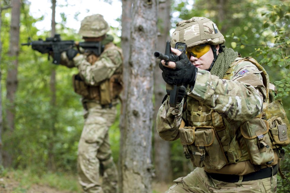 Two fully armed British soldiers on a mission in forest