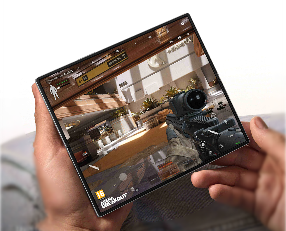 two hands holding open galaxy z fold 6 with first-person shooter Arena Breakout on Android showing on-screen