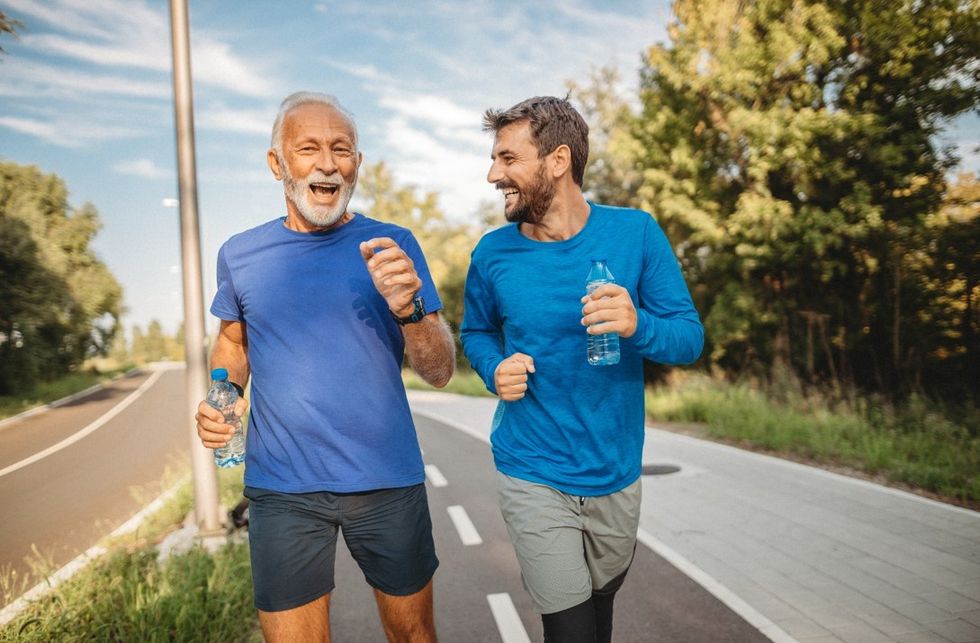 Two men jogging by a road