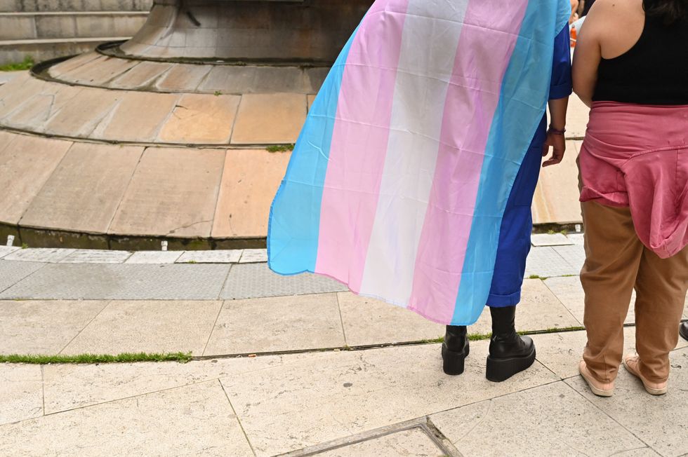 Two people waving a trans flag