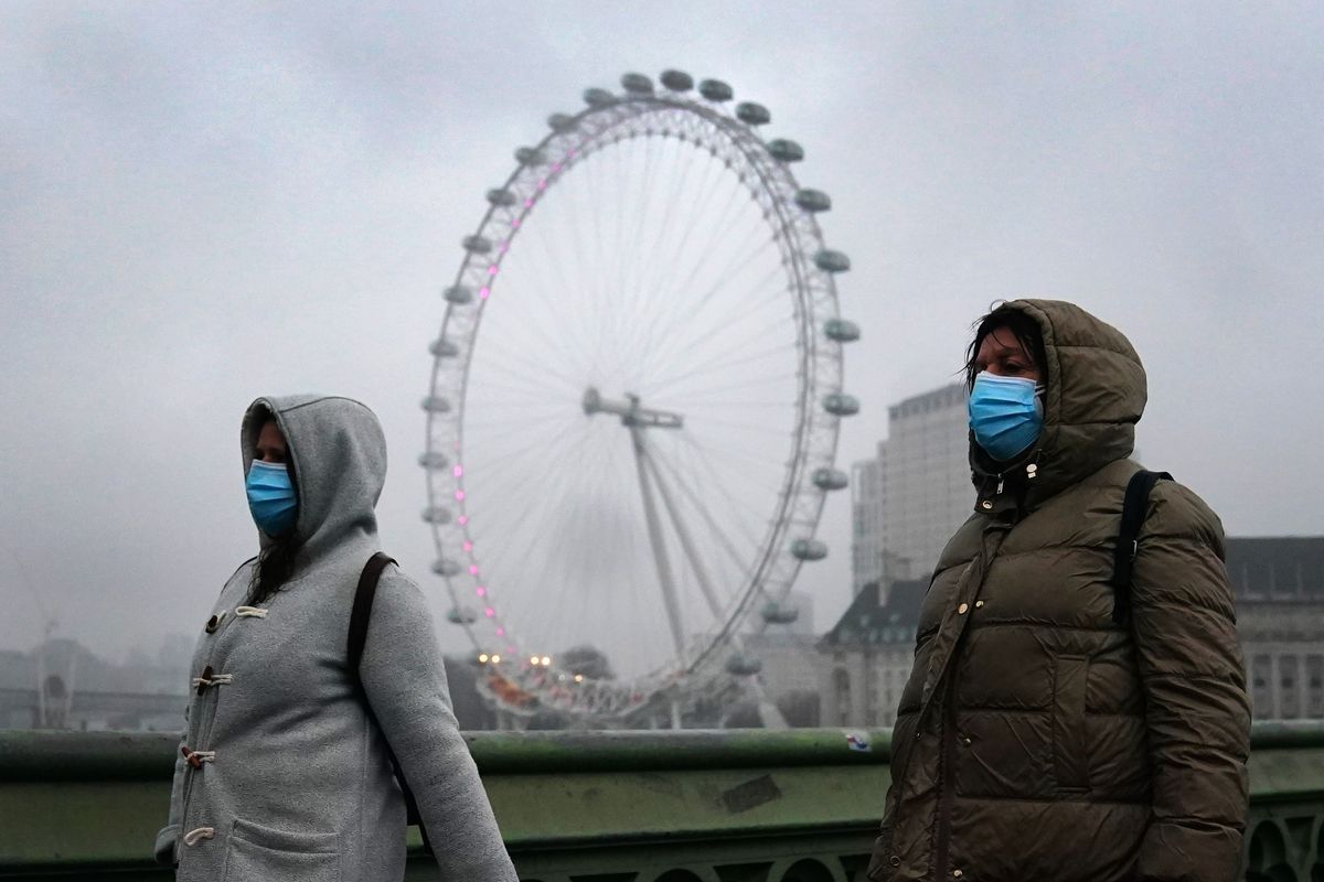 Two people wearing face masks walking in London