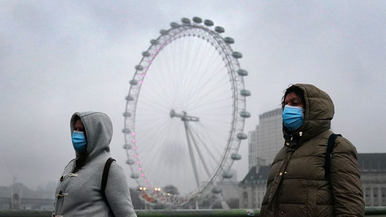 Two people wearing face masks walking in London