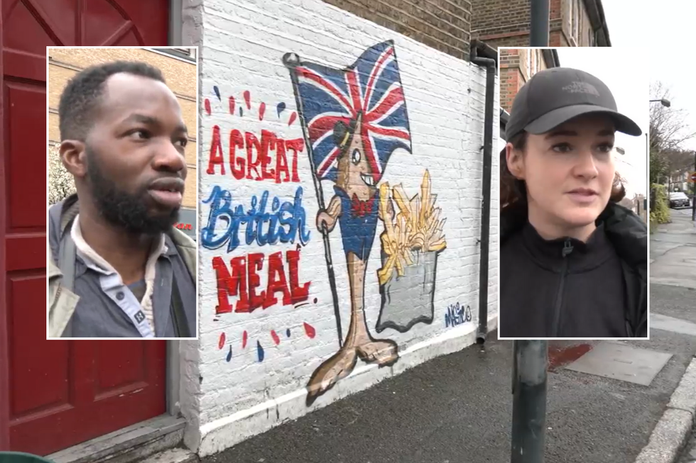 Two people with the mural in the background