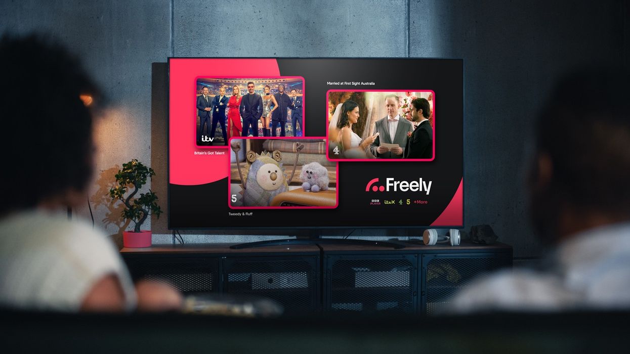 two people with their backs turned watching freely tv on a smart tv