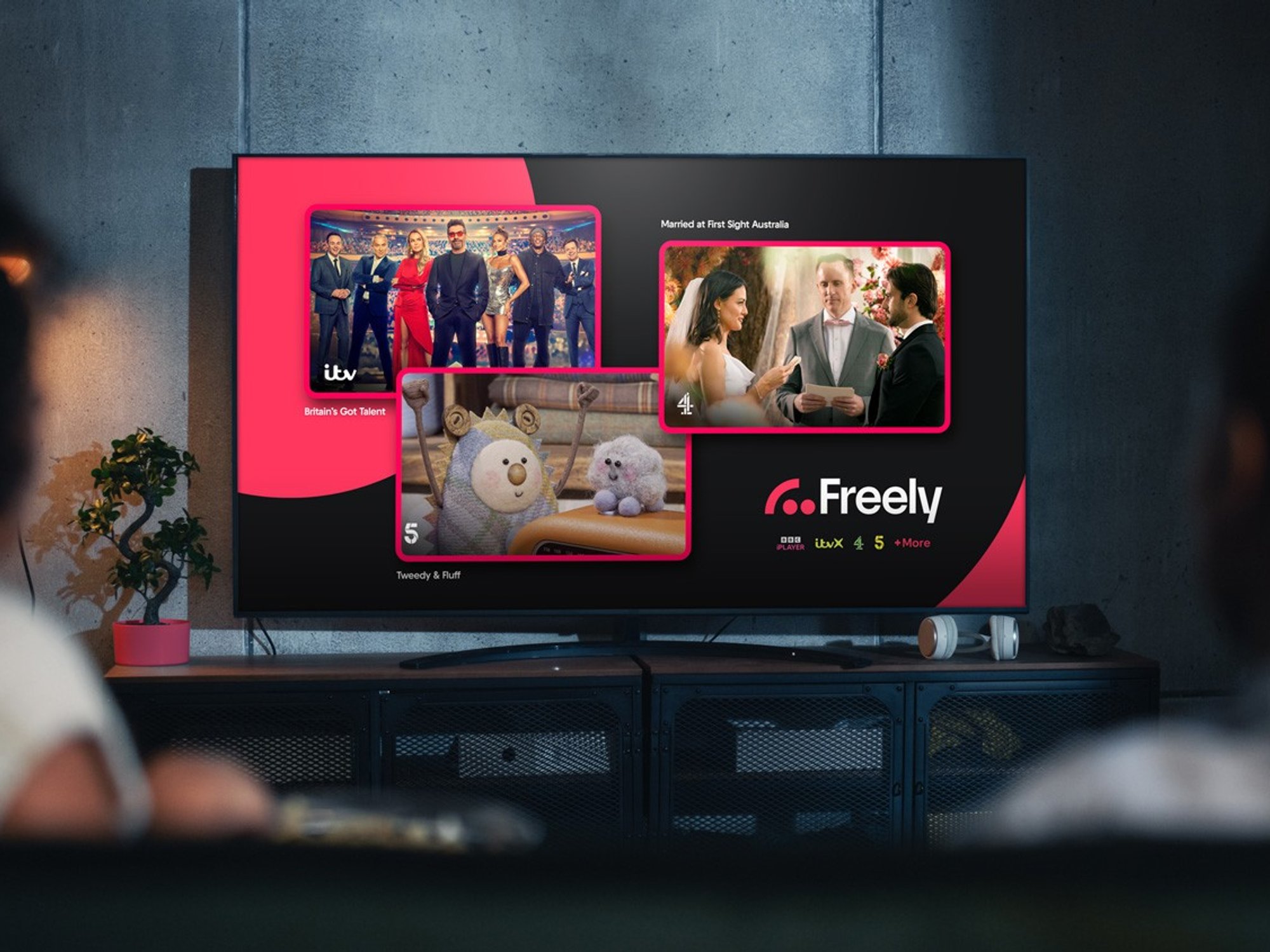 two people with their backs turned watching freely tv on a smart tv