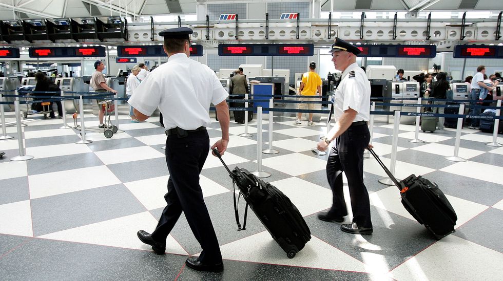 Two pilots walk through the United Airlines terminal at O'Hare International Airport May 31, 2005 in Chicago, Illinois