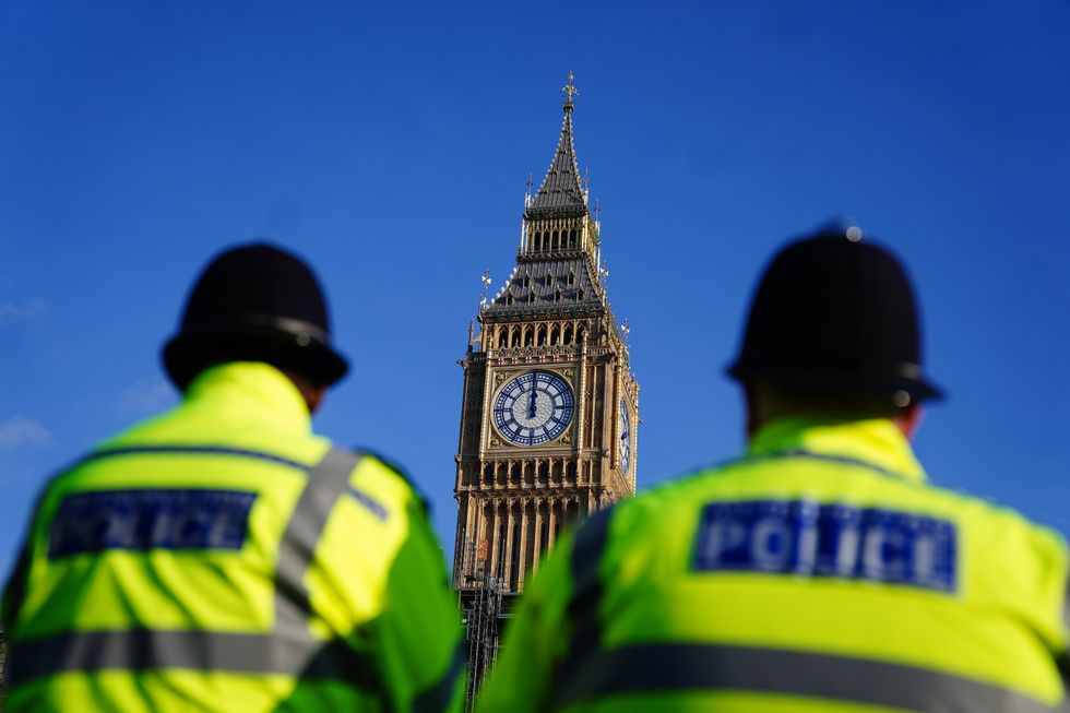Two police officers walk past the Elizabeth Tower, better known as Big Ben, at the Houses of Parliament in Westminster, London. The Prime Minister is set to face further questions over a police investigation into partygate as No 10 braces for the submission of Sue Gray's report into possible lockdown breaches. Picture date: Wednesday January 26, 2022.