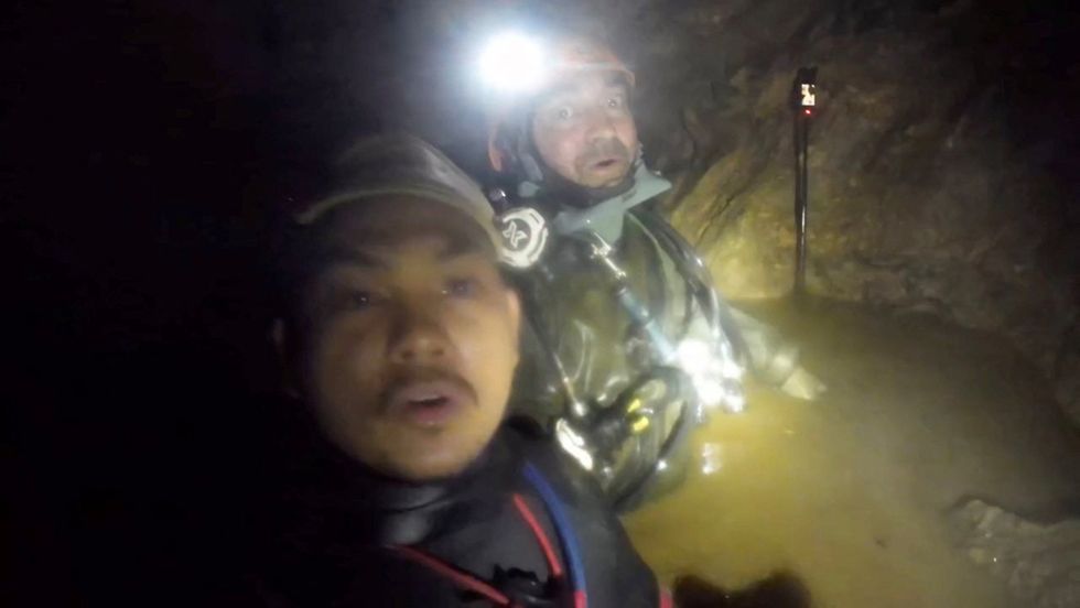Two rescue workers say that they have found five of the people who were trapped in a cave alive