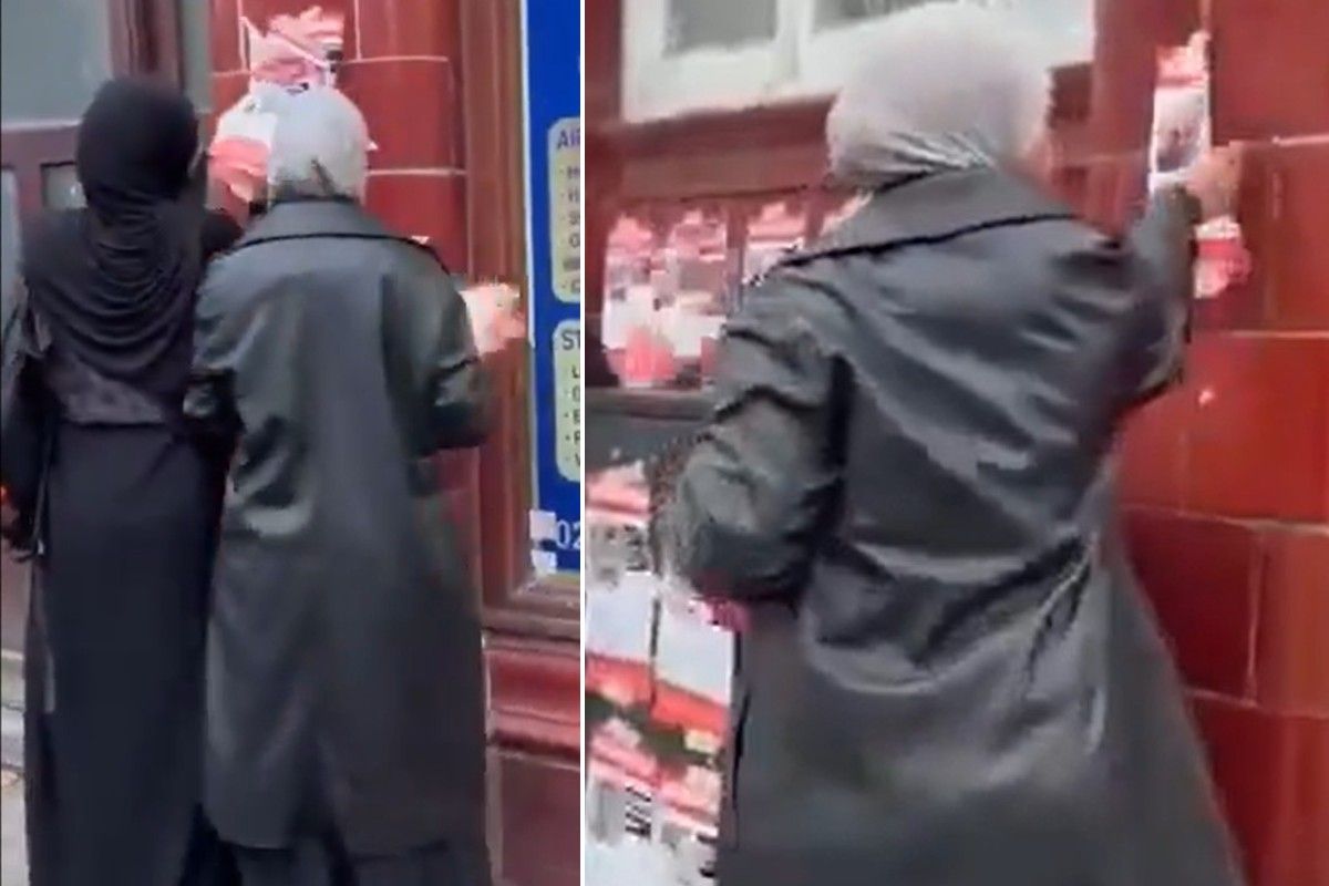 Two women seen ripping down posters in London
