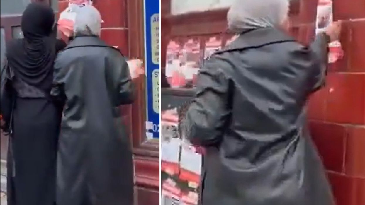 Two women seen ripping down posters in London