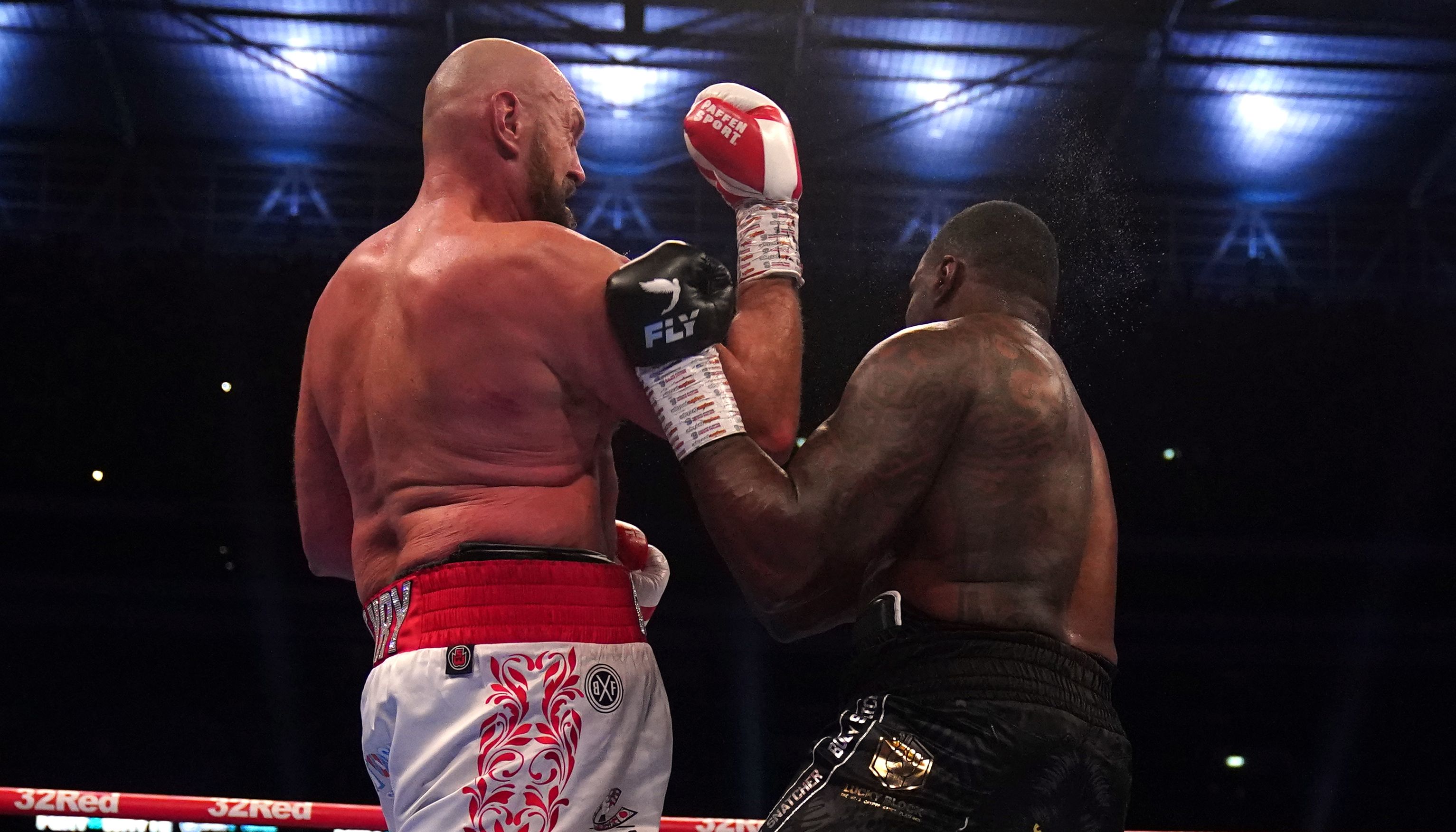 Tyson Fury (left) knocks down Dillian Whyte during the WBC heavyweight title fight at Wembley Stadium, London. Picture date: Saturday April 23, 2022.