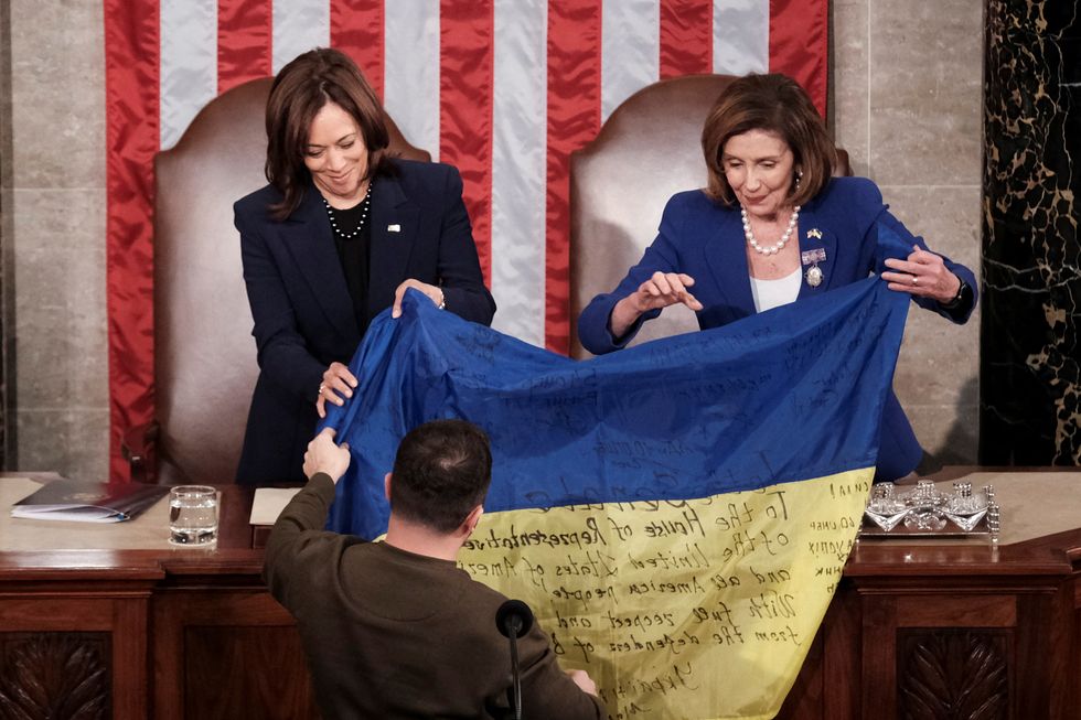 U.S. House Speaker Nancy Pelosi (D-CA) and U.S. Vice President Kamala Harris hold a Ukrainian flag presented by Ukraine's President Volodymyr Zelenskiy, given to him by defenders of Bakhmut, during a joint meeting of U.S. Congress in the House Chamber of the U.S. Capitol in Washington, U.S., December 21, 2022. REUTERS/Michael A. McCoy