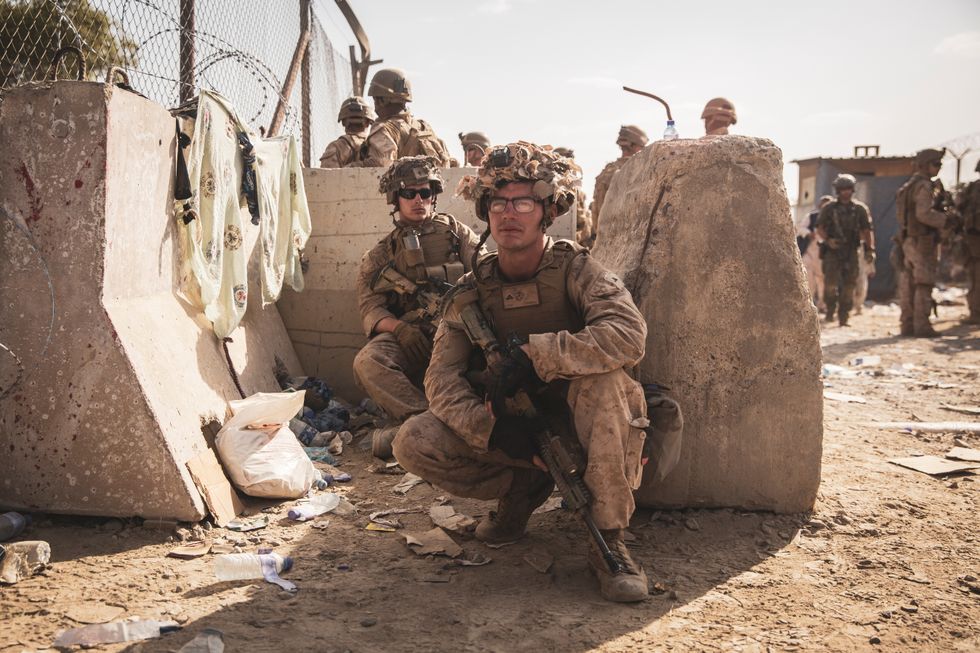 U.S. Marines take a moment to rest at an Evacuation Control Checkpoint during an evacuation at Hamid Karzai International Airport, Kabul.