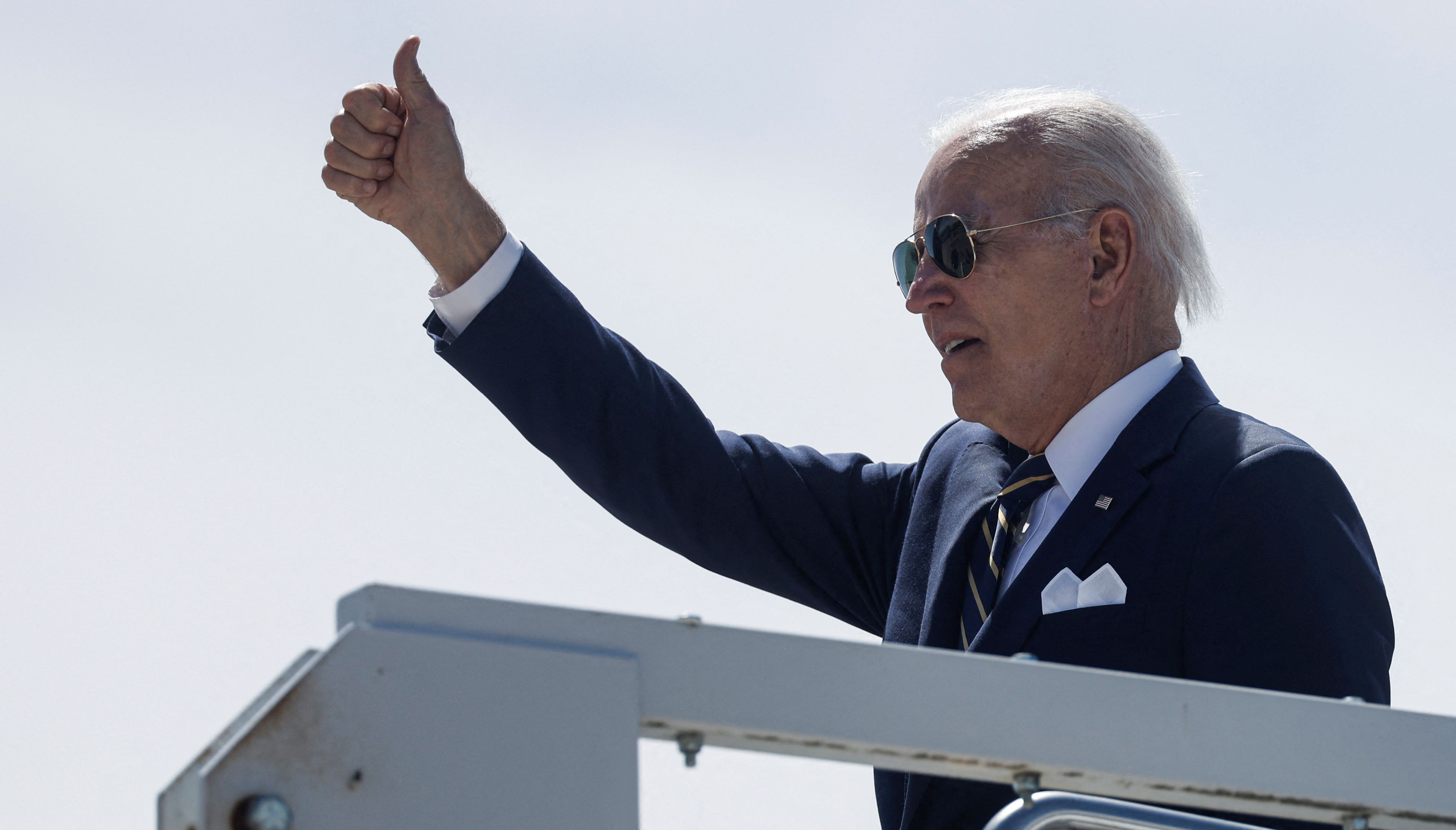 U.S. President Joe Biden gestures as he boards Air Force One to depart for Washington from Madrid