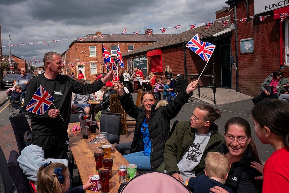 \u200b Members of the public enjoy a street party outside the Wilbraham Club