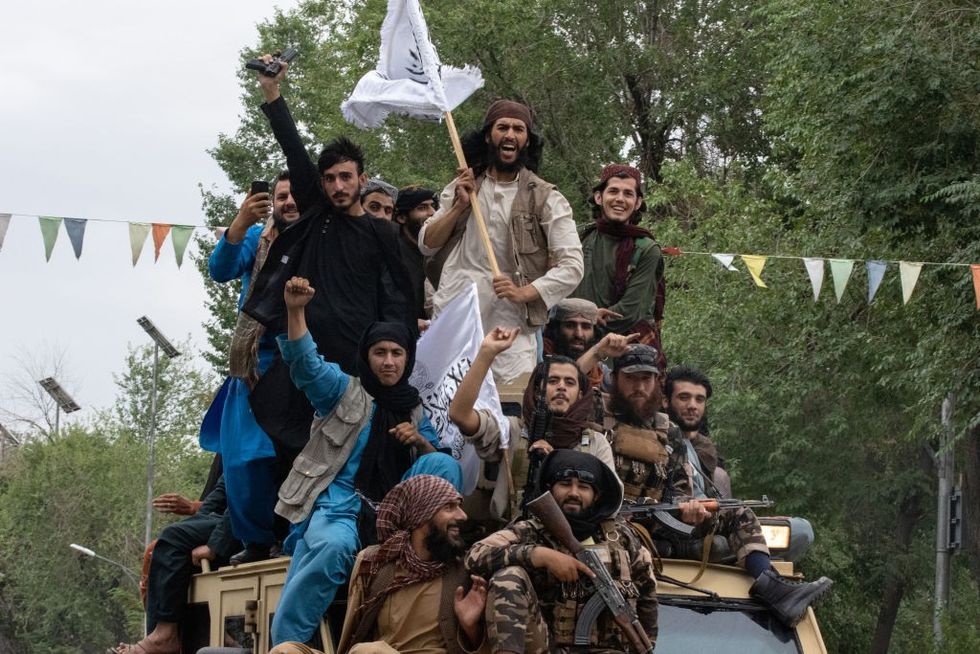 \u200b: Men ride on top of an armored vehicle during a celebration of the first anniversary of the Taliban's return to power on August 15, 2022 in Kabul