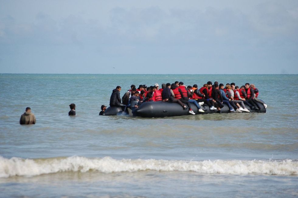 \u200b Migrants sit onboard an inflatable boat before attempting to illegally cross the English Channel to reach Britain,