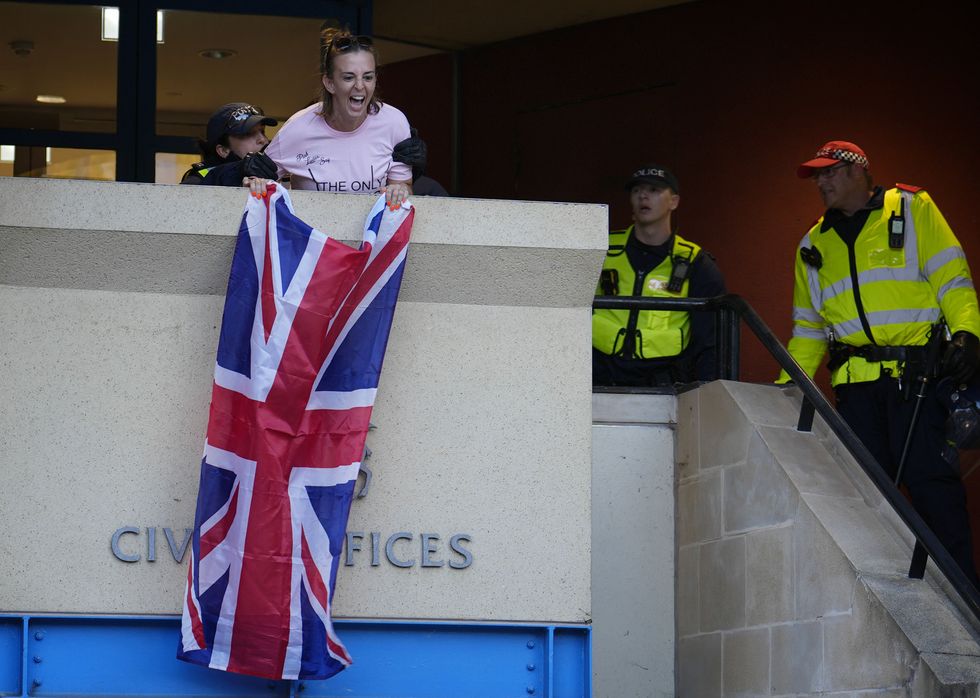 \u200b Ms White held a Union flag from the civic offices before being detained by police,