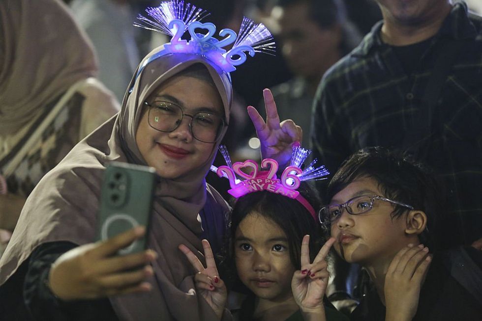 \u200b People wearing '2026' head bands attend New Year celebrations welcoming 2026 in Jakarta